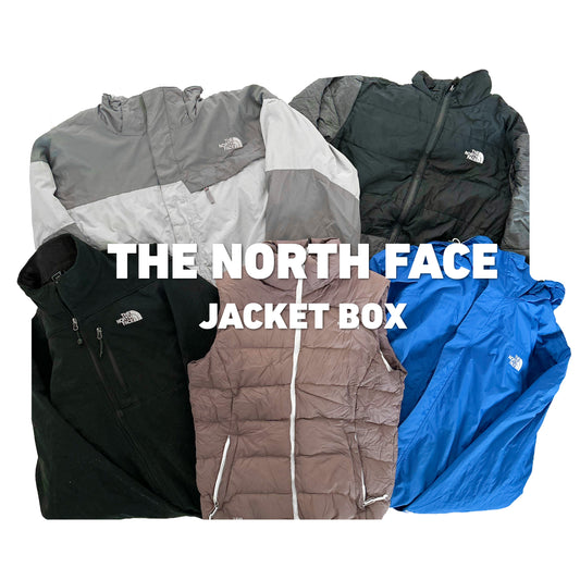 The North Face Jacket Box met een bruine puffer bodywarmer, een zwart fleece jack, een blauwe windbreaker en tweekleurige outdoor jassen.